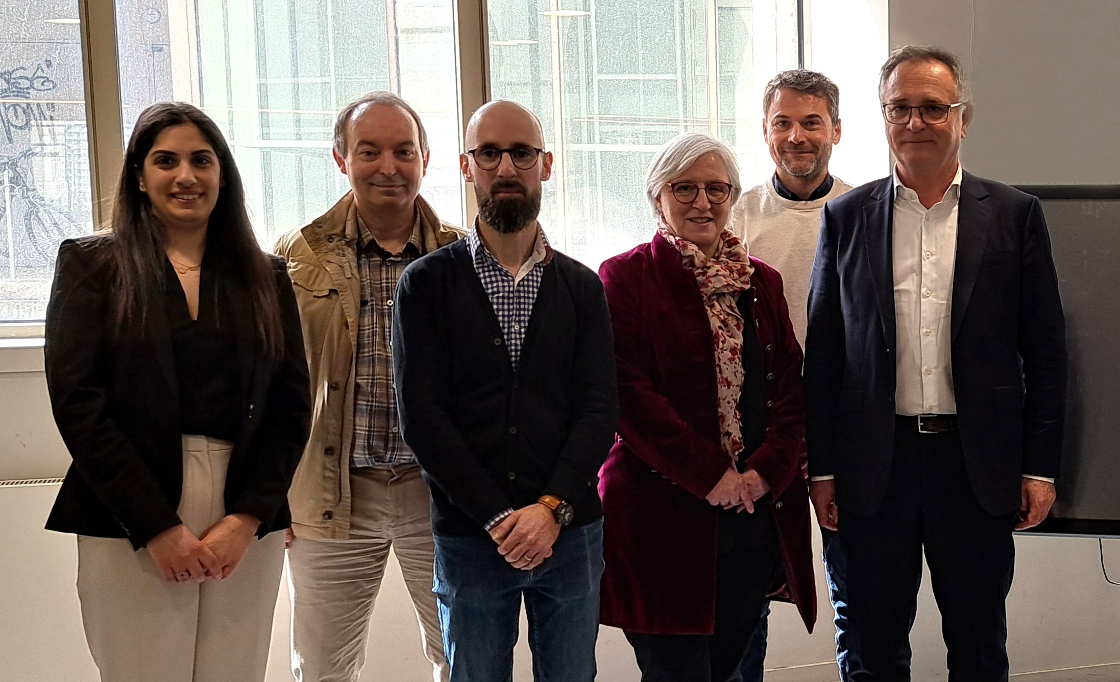 Groupe de six personnes, hommes et femmes, alignés.