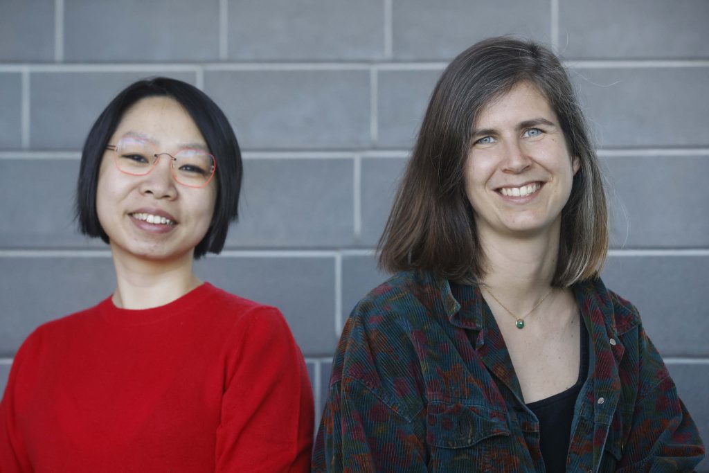 Femme de type asiatique et femme de type caucasien souriantes.
