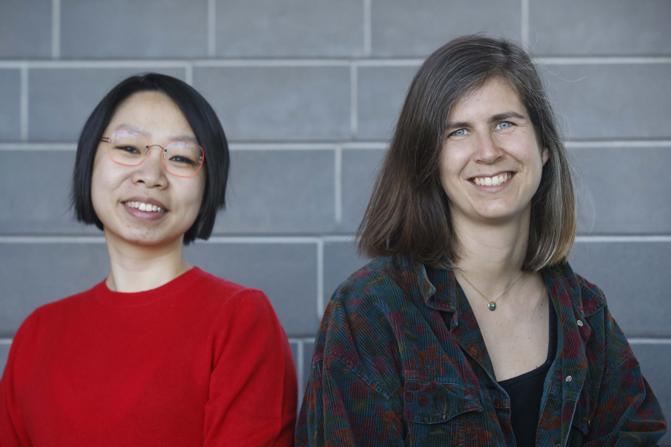 Femme de type asiatique et femme de type caucasien souriantes.
